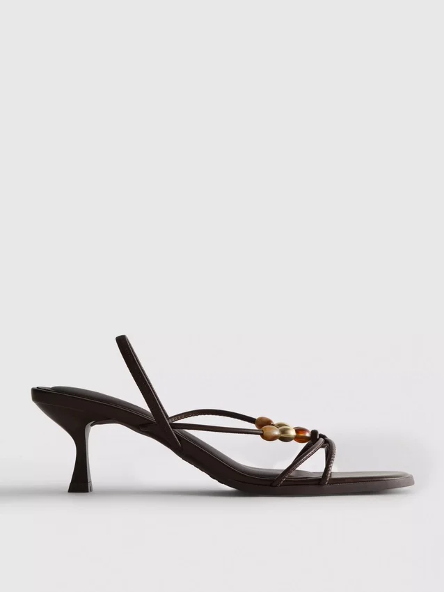 Helmillä koristellut kitten-heel-sandaalit