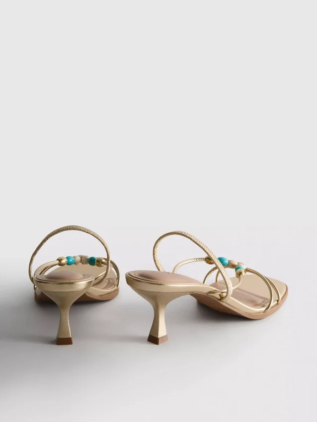 Helmillä koristellut kitten-heel-sandaalit