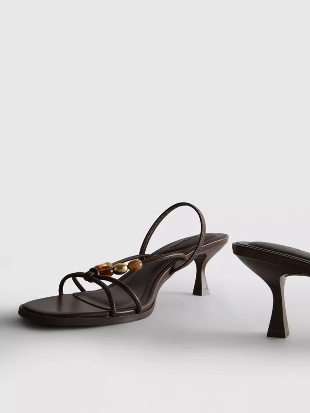 Helmillä koristellut kitten-heel-sandaalit