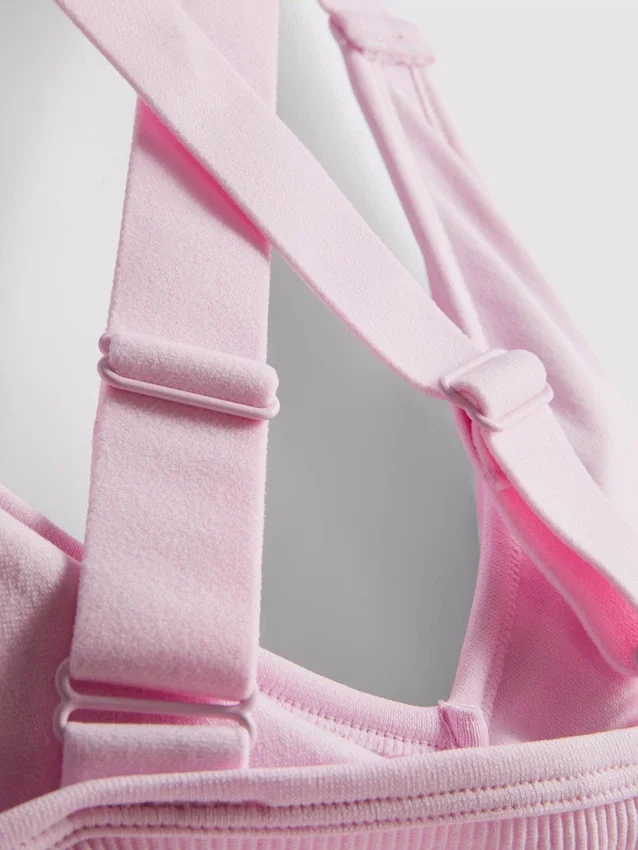 Saumaton, selän takaa ristikkäin menevä urheilullinen crop-toppi