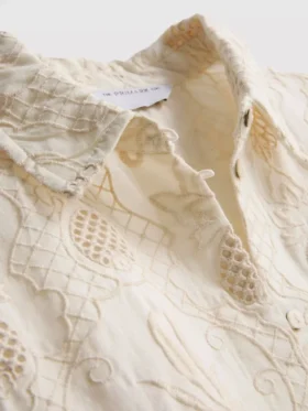 The Edit -kauluspaita, jossa kaareva helma ja broderie-koristeet