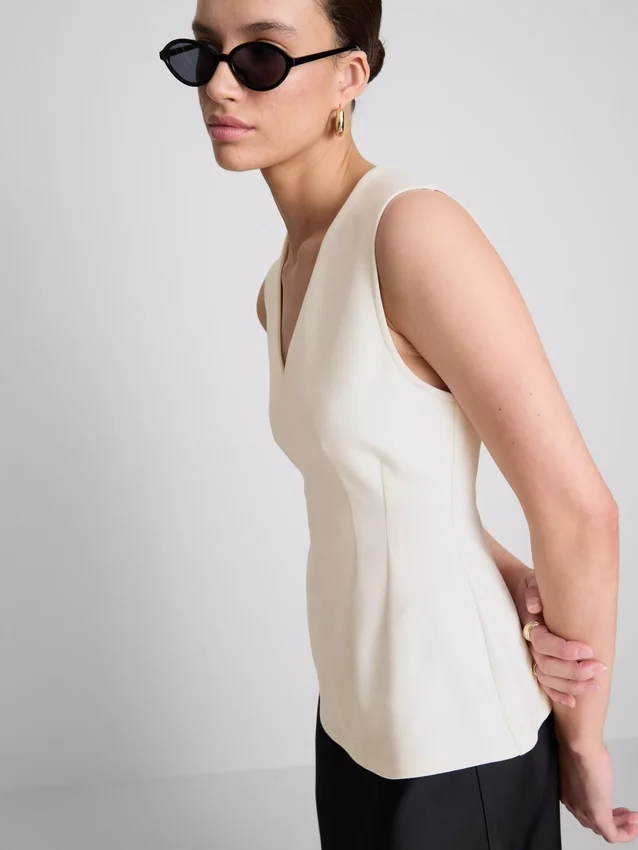 V-kaula-aukkoinen peplum-hihaton toppi