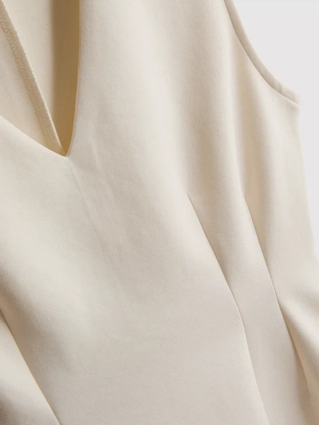 V-kaula-aukkoinen peplum-hihaton toppi