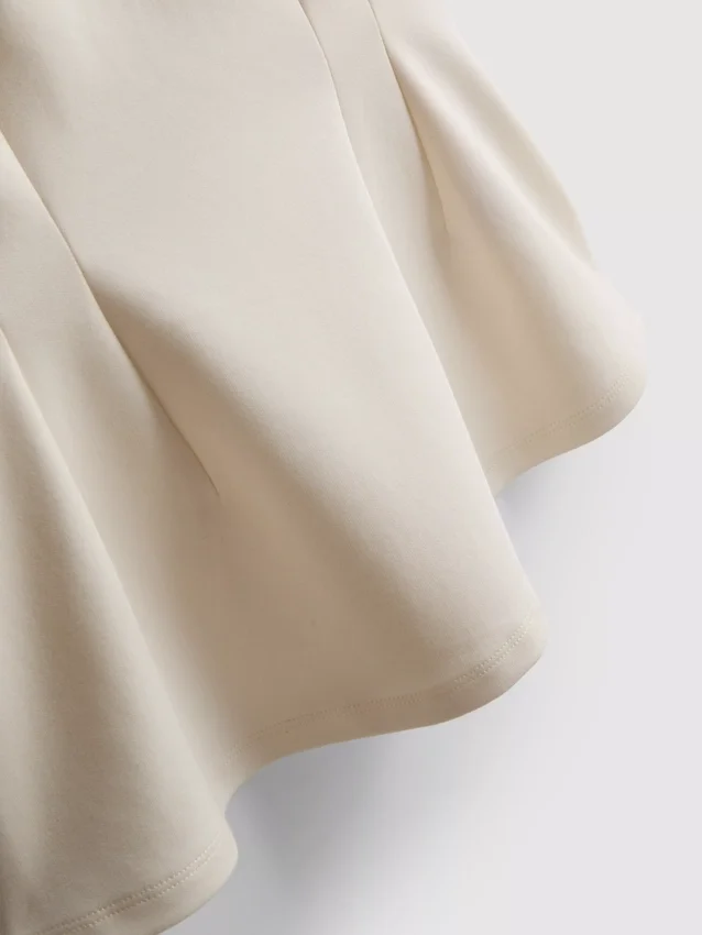 V-kaula-aukkoinen peplum-hihaton toppi